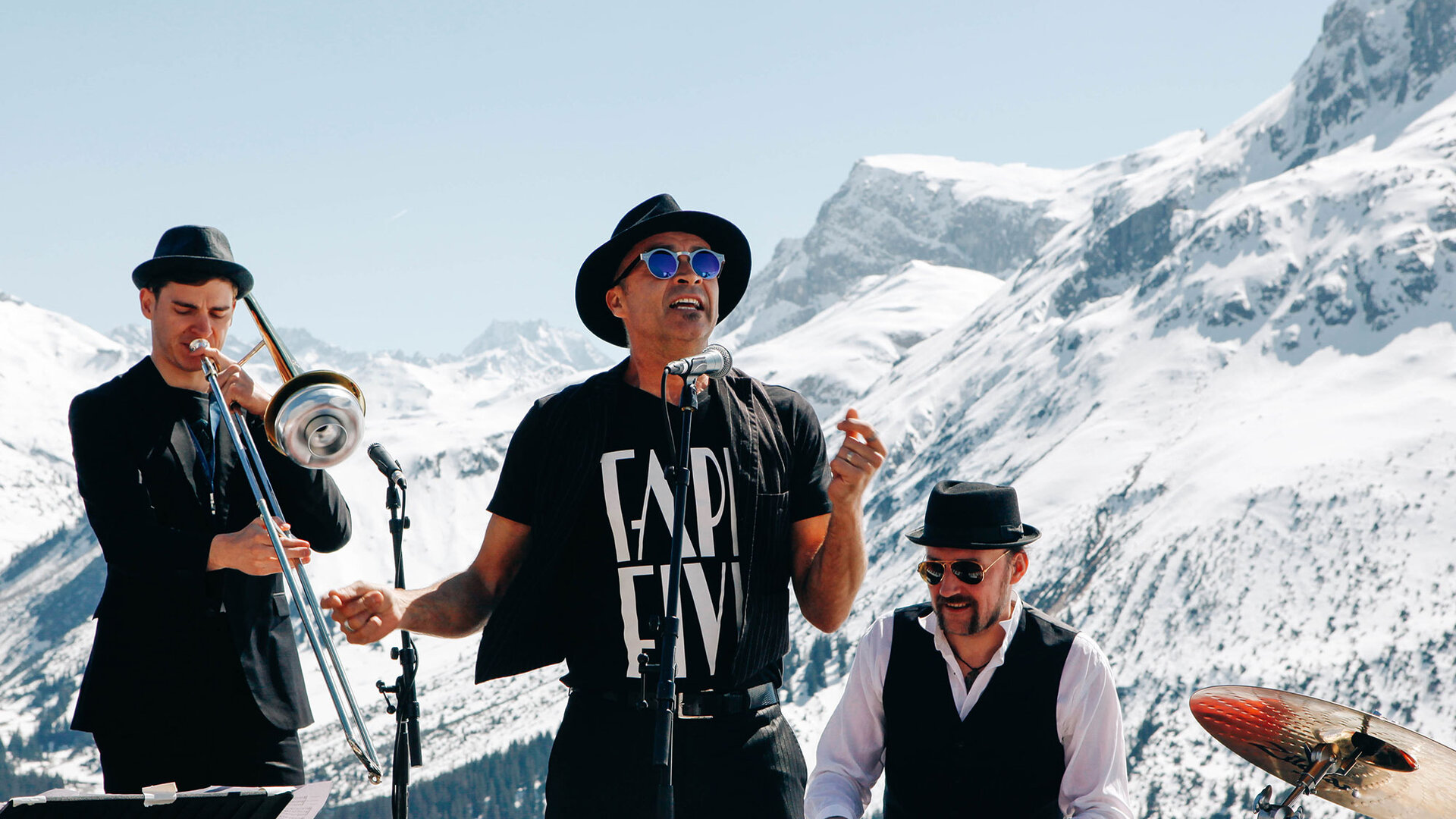 Musikband vor verschneiten Alpengipfeln